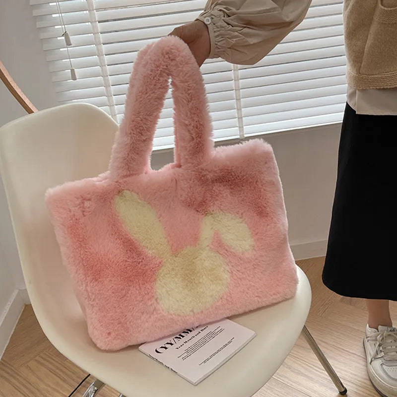 Plush shoulder bag with cartoon rabbit ears design in a solid colour.