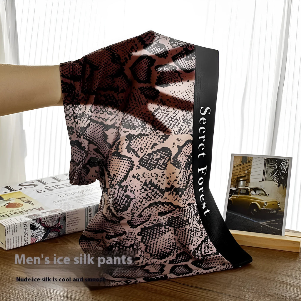 Men's thin loose polyester boxer shorts in black on grey background showing mid-waist design