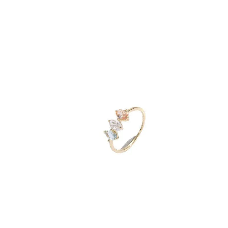 Gold colour geometric triangle ring with horse eye design and tricolour zircon stones on a white background