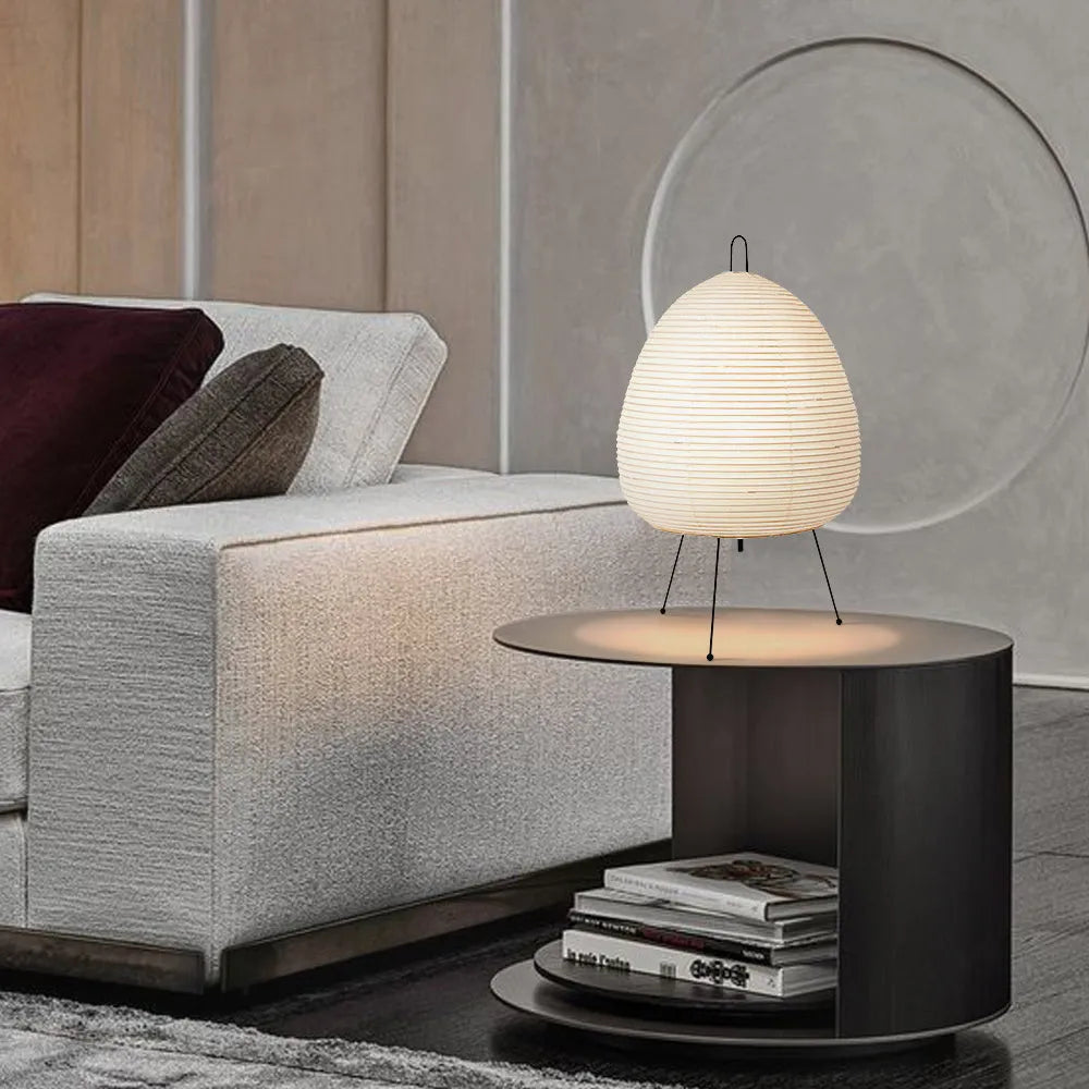 Nordic style table lamp with a handmade Japanese rice paper shade and aluminium base on a wooden table.