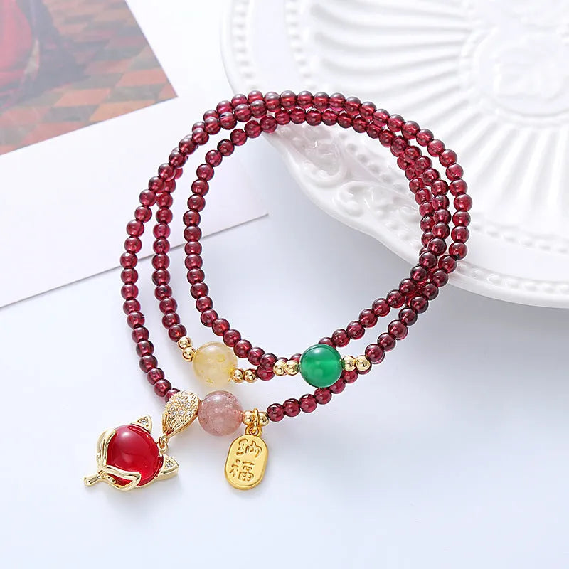 Purplish red garnet fox bracelet on an adjustable rope for women.