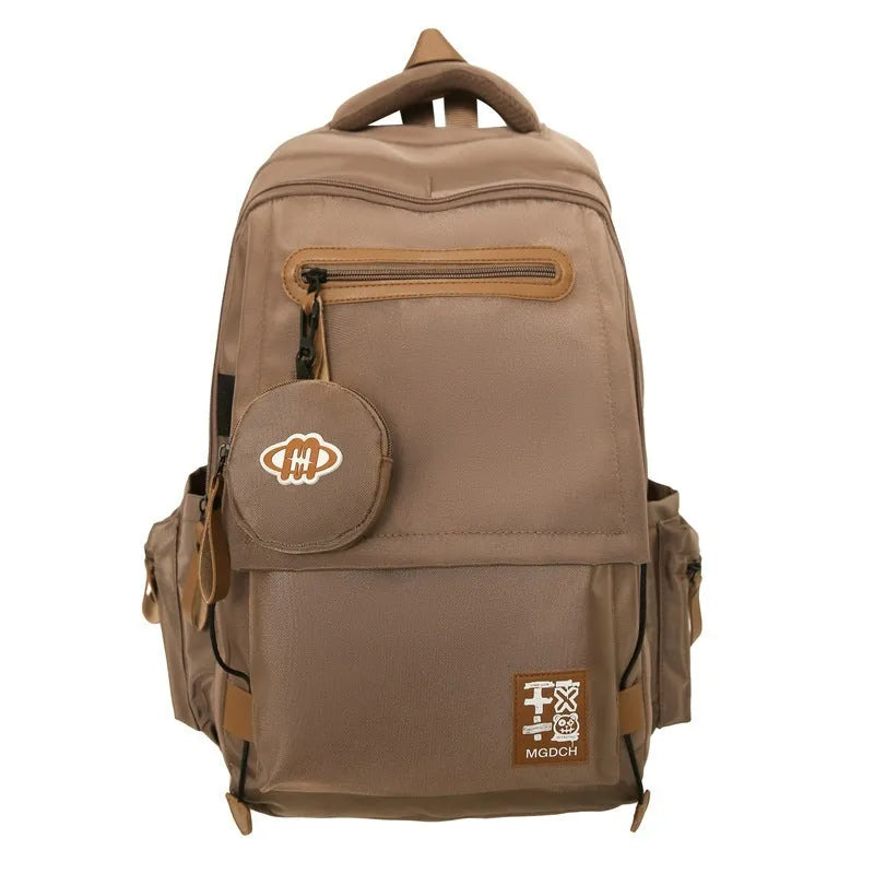 Street style large capacity nylon backpack for middle school students in solid colour with curved shoulder straps.