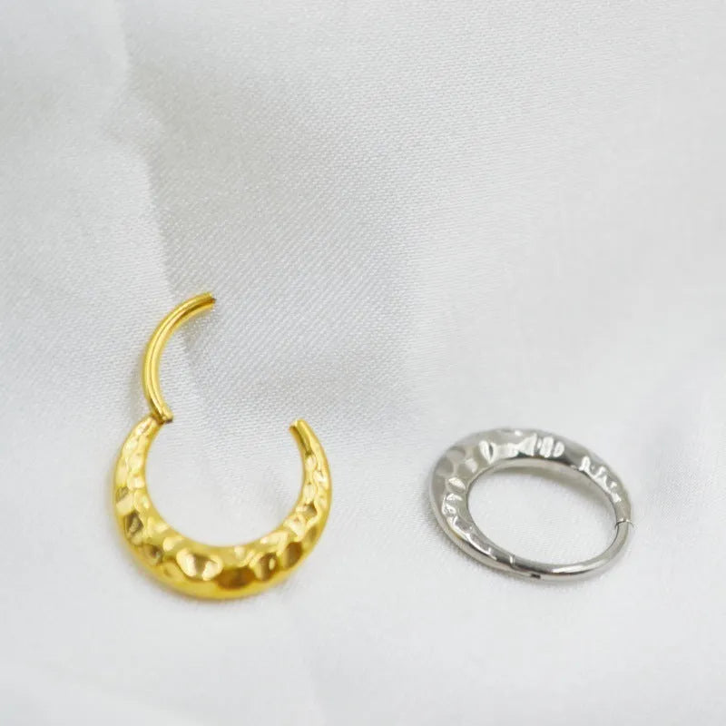 Close-up of a carved concave-convex titanium nose ring in silver finish