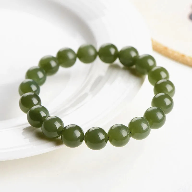 Polished Hetian jade ball bracelet in ice-like clear water colours on a wrist.