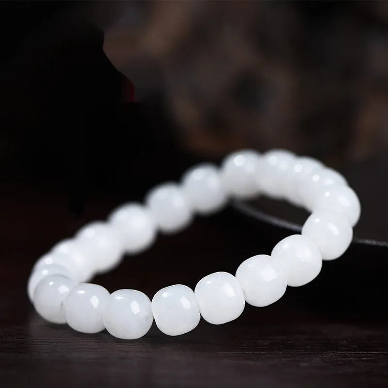 White Hetian jade barrel bead bracelet on a wrist, showing the smooth stone beads and unisex casual design.
