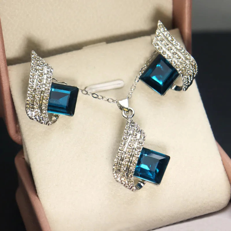 Women's jewellery set showing necklace with cross chain and matching earrings with glass elements