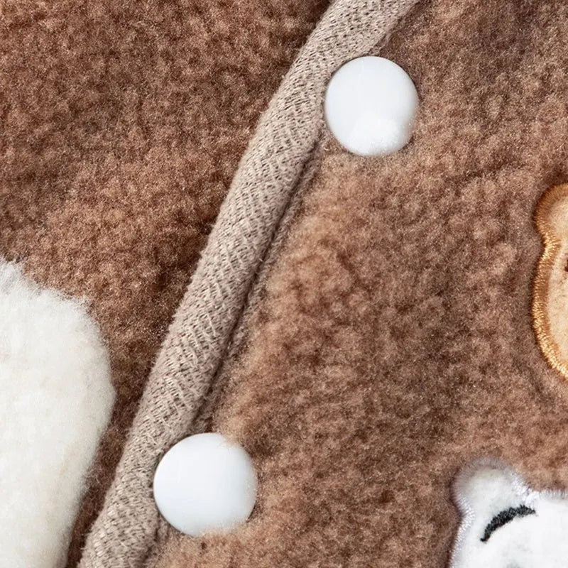 Brown fleece dog coat with bear embroidery and side-button closure on a small dog