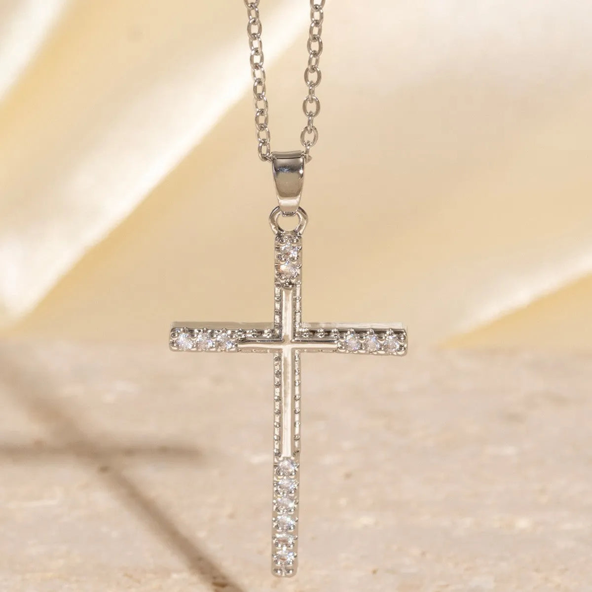 Gold electroplated copper cross necklace with micro inlaid zircon on a 41-50cm O-ring chain.