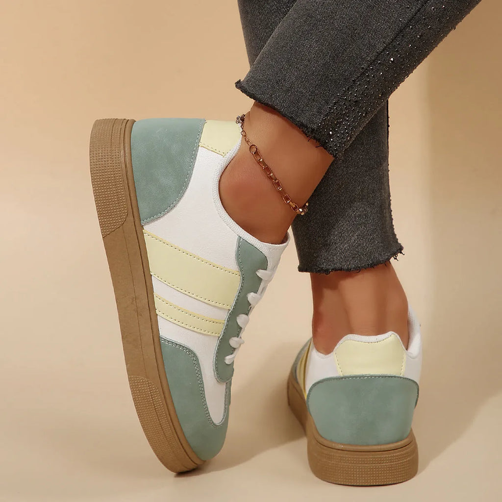 Green women's retro sports pumps with cross straps, flat rubber sole, and round toe on a white background.