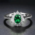 Women's copper flower ring with moissanite inlay in sapphire blue, red, or green on a model's hand.