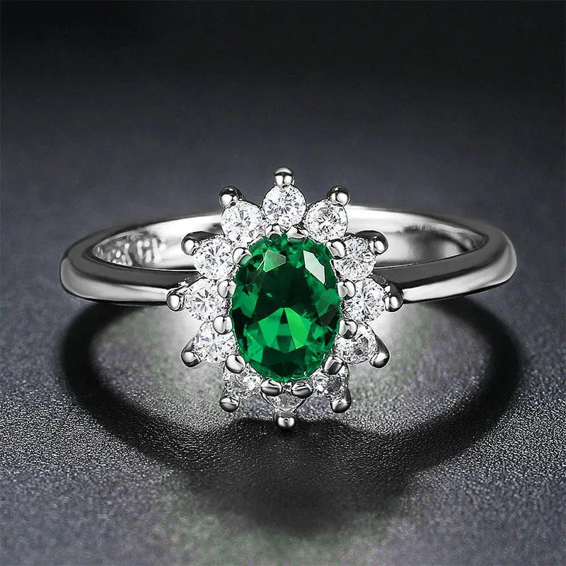 Women's copper flower ring with moissanite inlay in sapphire blue, red, or green on a model's hand.