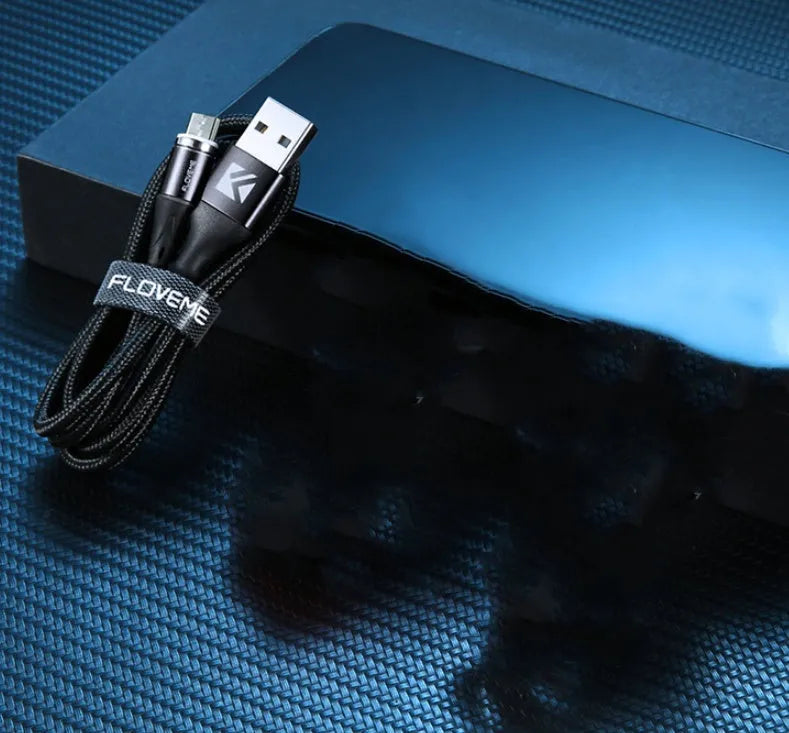 Black magnetic data cable with LED light on connector next to smartphone