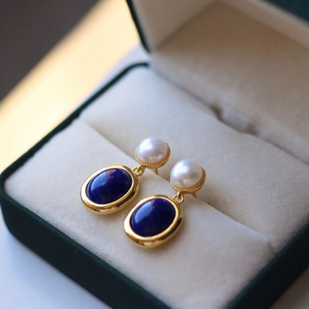 A pair of sterling silver earrings with deep blue lapis lazuli pearls and simple auspicious patterns.
