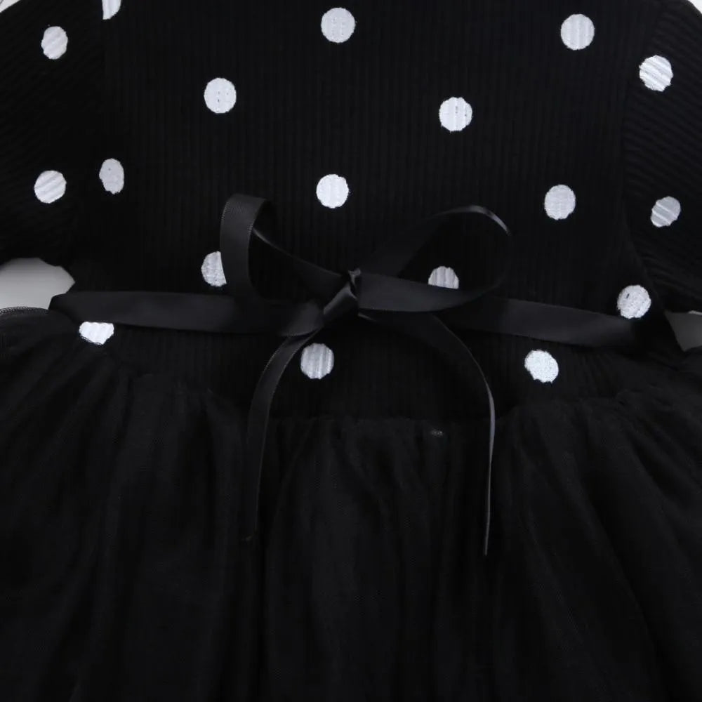 Baby girl in a long sleeve black lace tutu dress, suitable for christenings and parties.
