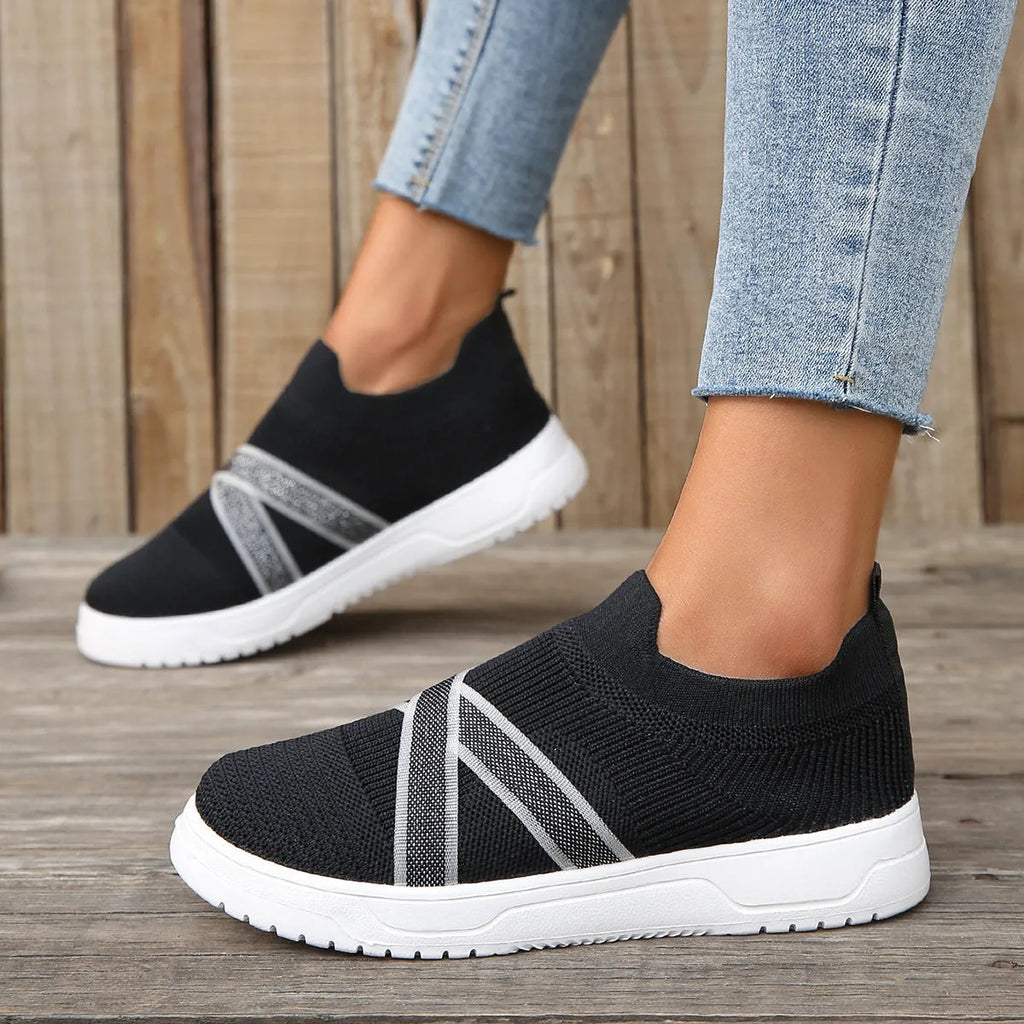 Black women's flat casual shoes with fabric mesh uppers, tassel detail, and a rubber sole.
