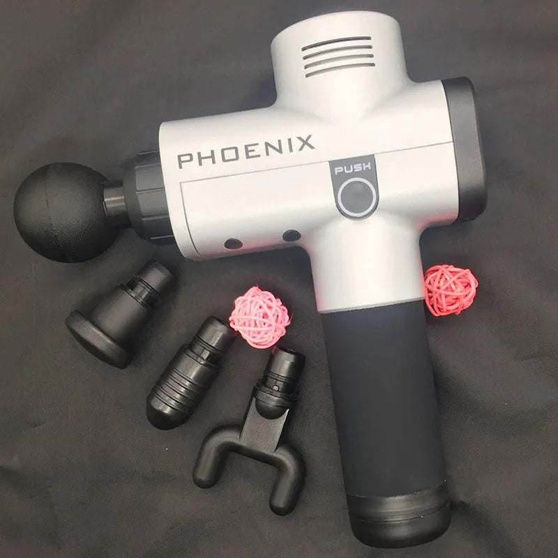Black fascia massage gun with four different coloured massage heads on a table