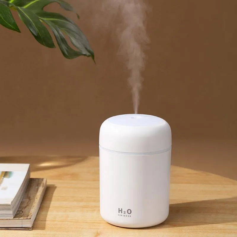Pink USB portable humidifier with 300ml tank and colourful lights on a desk