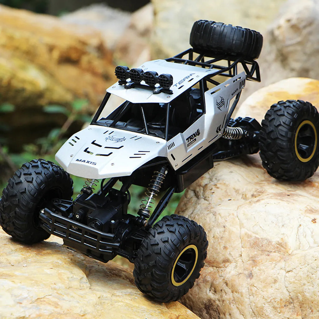 Black and silver 2.4G wireless remote control four-wheel drive car on a rough surface.