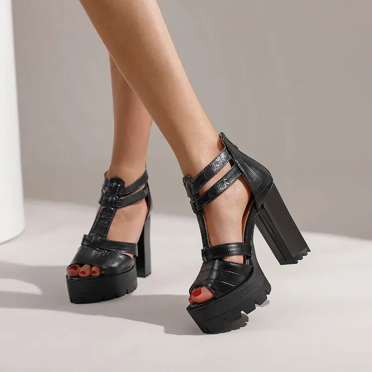 A pair of black platform high heel sandals with a back zipper and round toe on a rubber sole.