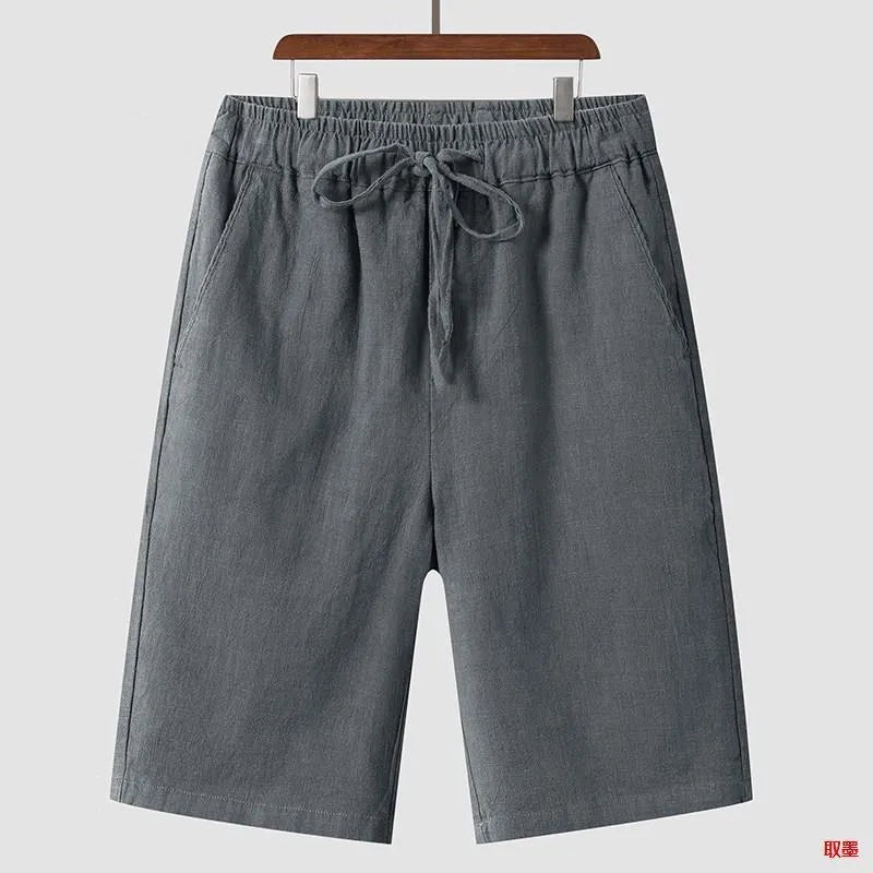 Man wearing beige linen cropped shorts with a loose fit and elasticated waistband.