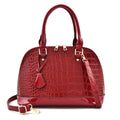 Shiny black PU leather crossbody bag with a structured shell shape, shown with a shoulder strap.