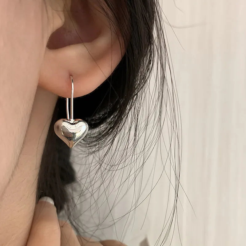 Silver heart-shaped earrings with glossy finish and ear hook fitting