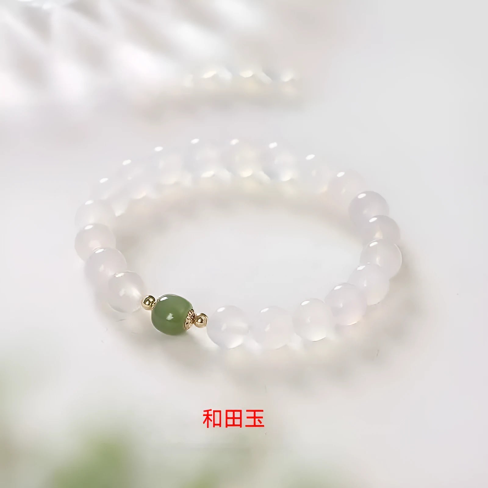 Handmade white agate and crystal bracelet with red cinnabar inlay and text charm.