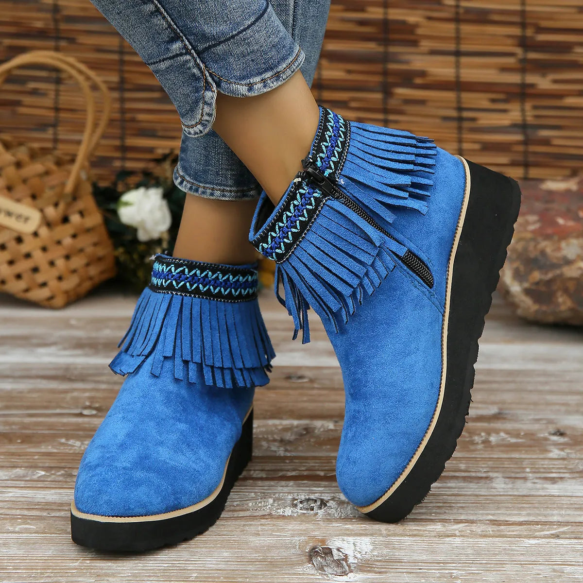 Women's suede ankle booties with a wedge heel, side zipper, tassel detail, and thick rubber sole.