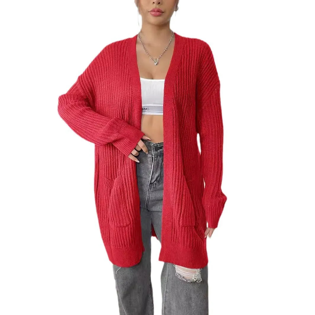 A loose-fitting, mid-length acrylic cardigan sweater in a solid colour, shown in a street hipster style.