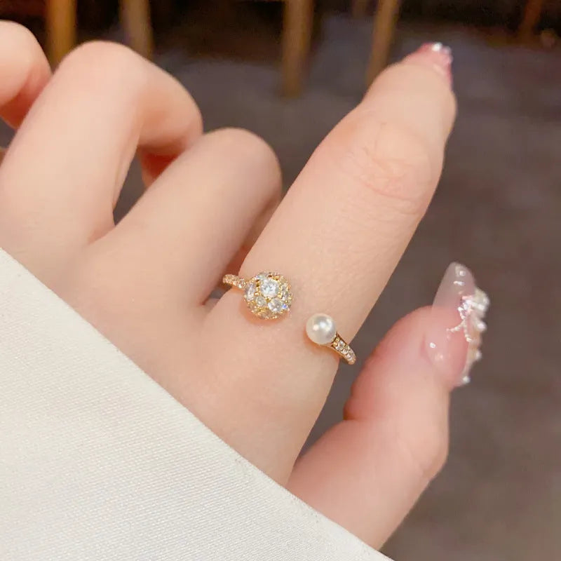 Open-end pearl ring with round zircon stones in geometric design with gold plating