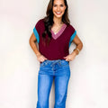 Burgundy loose sweater with contrast trim, V-neck, and cuffed short sleeves.