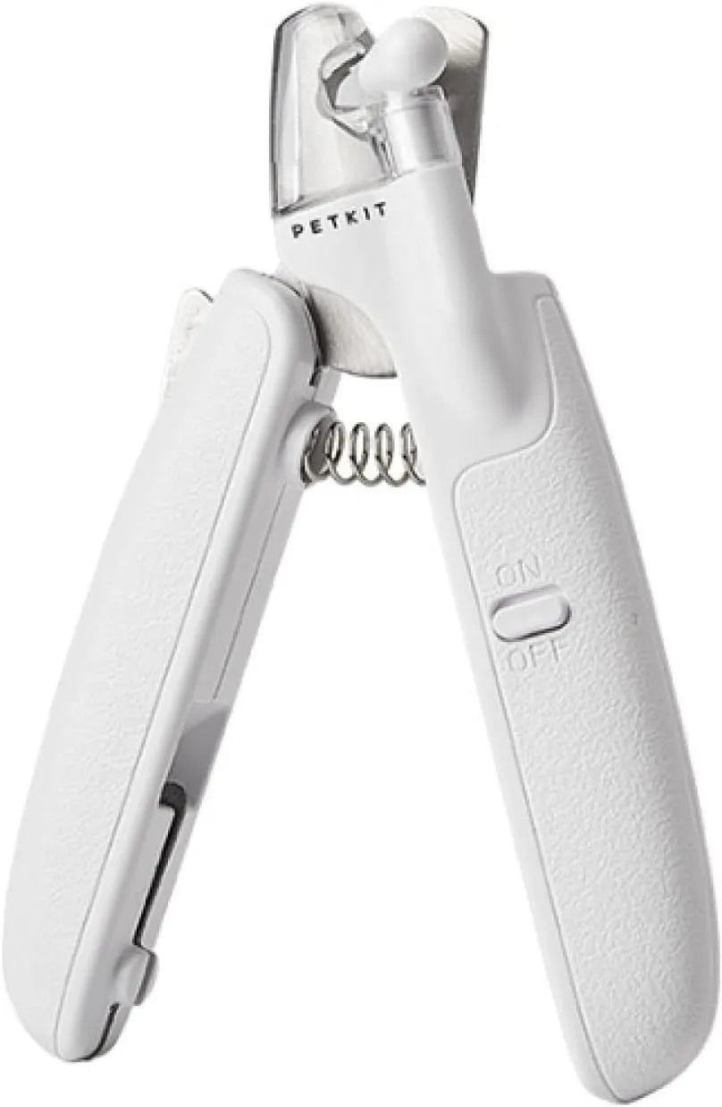 White pet nail clippers with LED light, transparent guard, and a nail file on a table