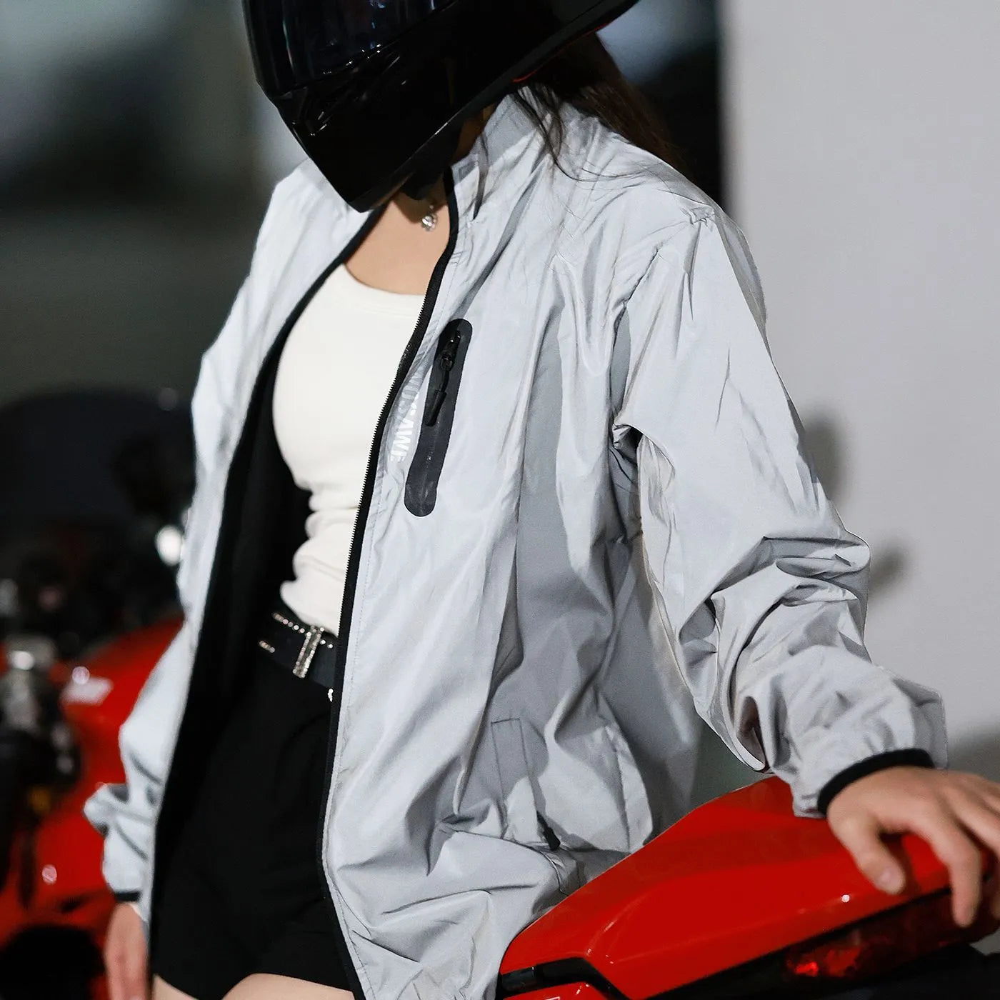 Silver waterproof polyester long-sleeved top displayed on a hanger, showing full sleeves and front closure.