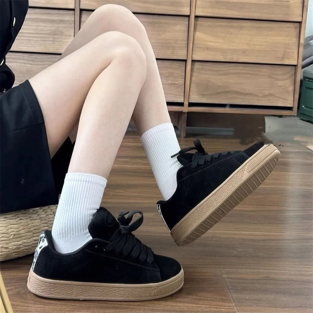 Black retro low-top sneakers with lace-up front, waterproof platform, and round toe design