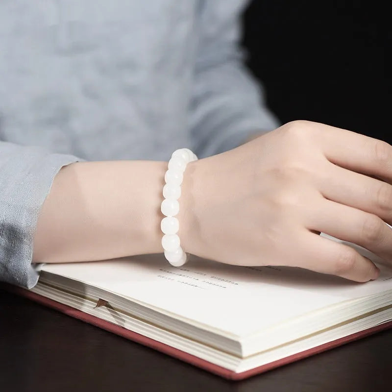 White Hetian jade barrel bead bracelet on a wrist, showing the smooth stone beads and unisex casual design.