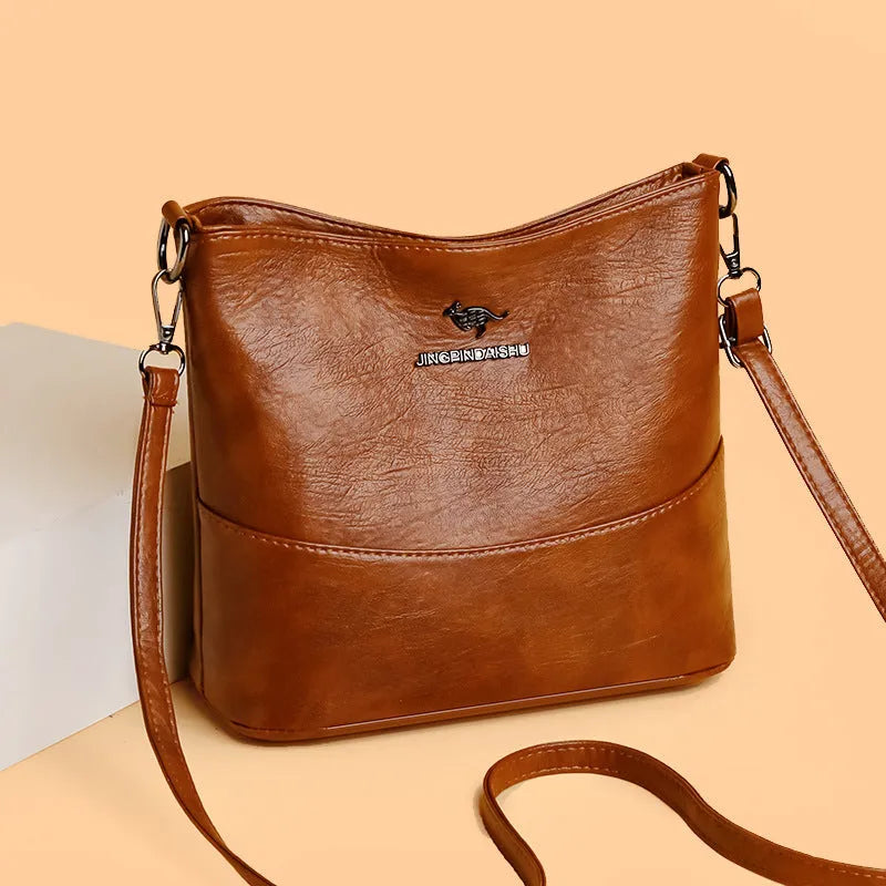 Women's soft leather bucket shoulder bag in black with minimalist design and interior phone pocket