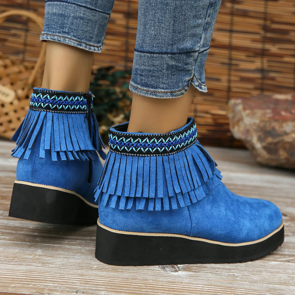 Women's suede ankle booties with a wedge heel, side zipper, tassel detail, and thick rubber sole.
