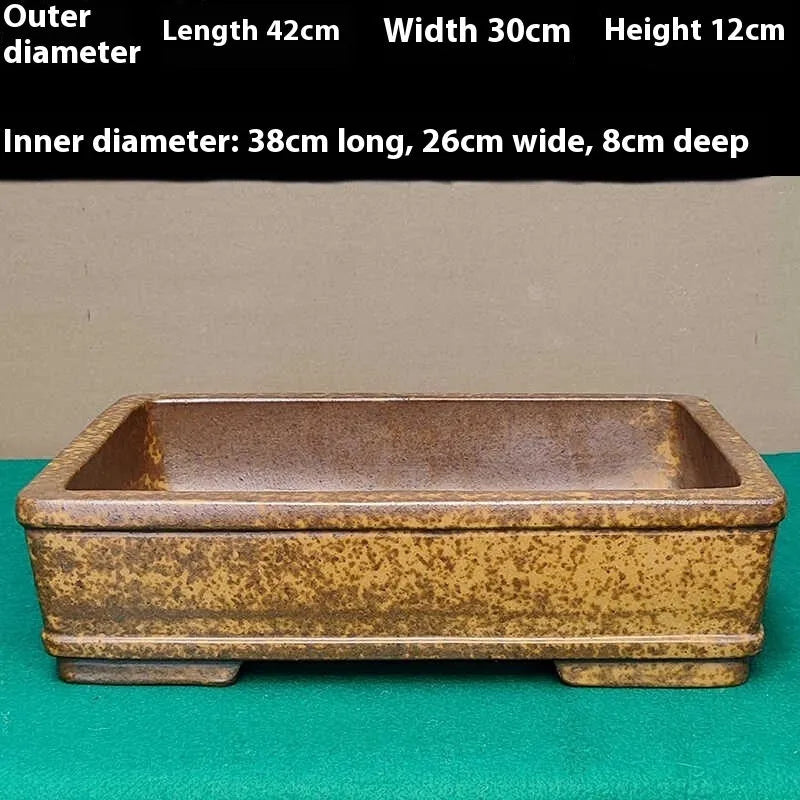 Straight shallow rectangular Yixing zisha purple sand flowerpot on a solid surface.