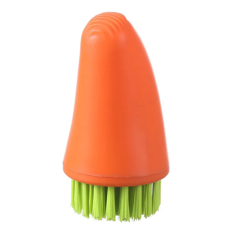 Orange and white carrot-shaped nylon kitchen cleaning brush with radish pattern on a wooden surface.