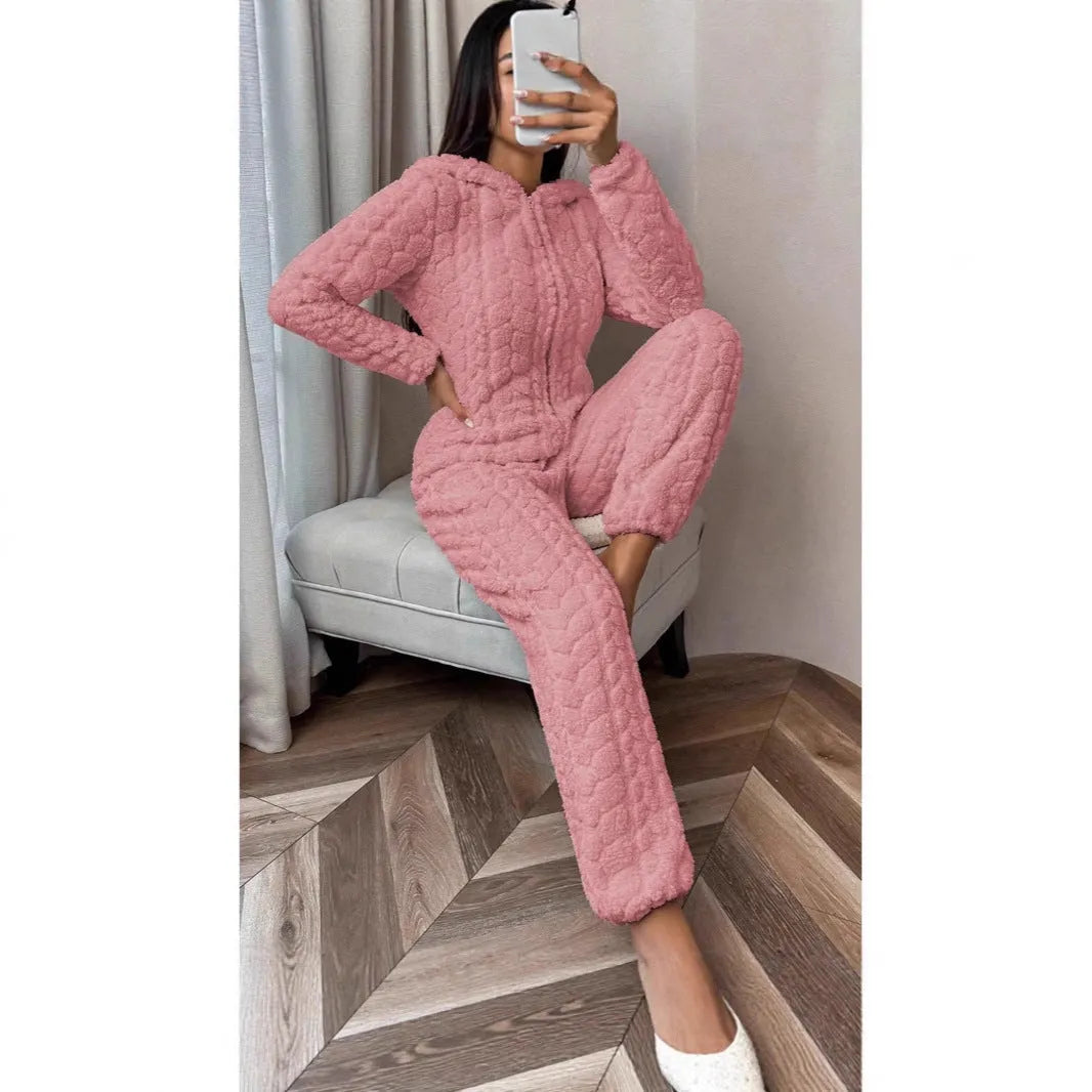 Beige hooded thickened coral fleece one-piece pajama with long sleeves on a woman standing indoors
