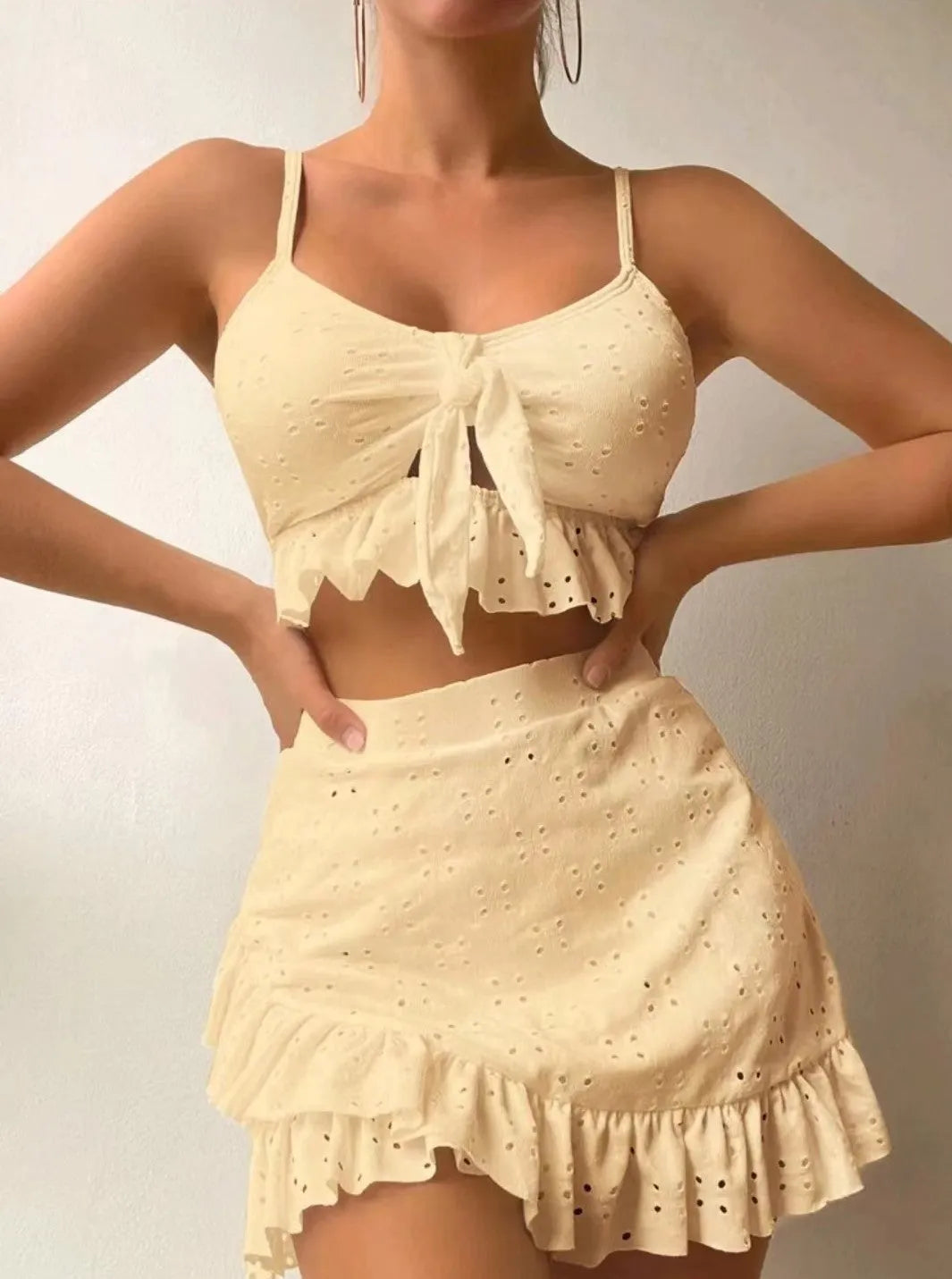 Women's white three-piece bikini set with a split hip skirt, made from polyester.