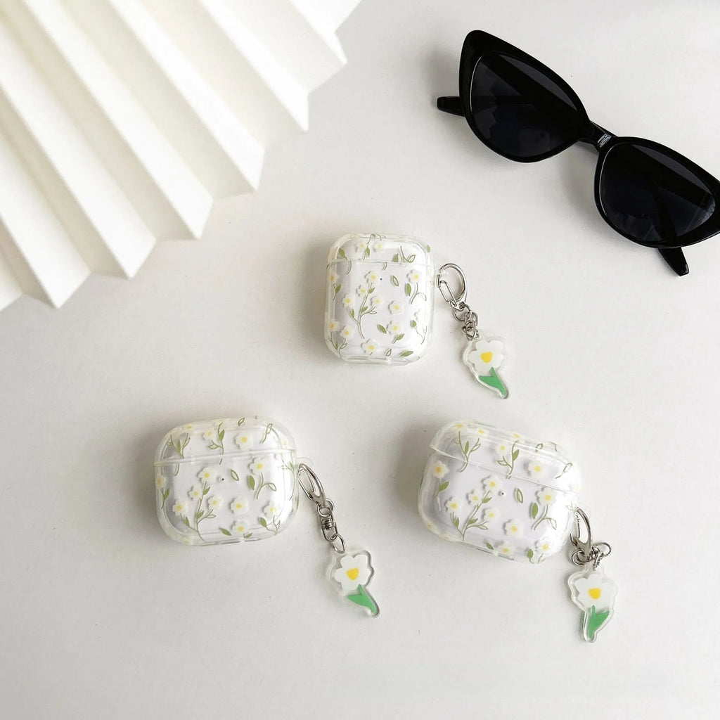 Transparent white floral TPU protective case for Apple AirPods headphones on a table.