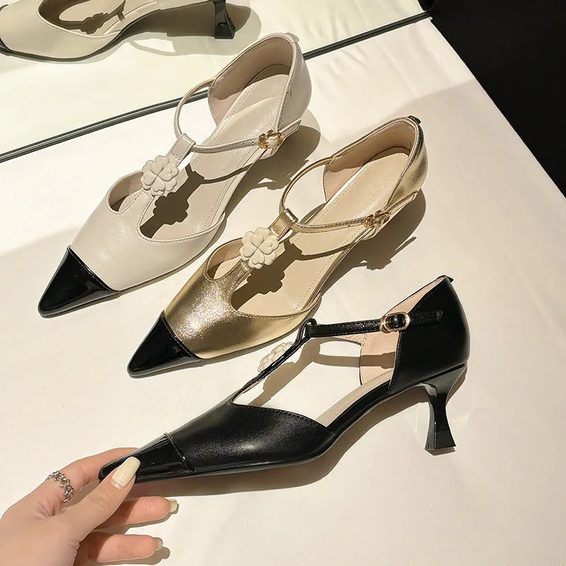 Women's gold stiletto shoe with floral detail, pointed toe, and a shallow cut opening.