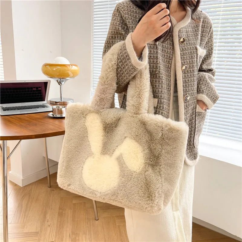 Plush shoulder bag with cartoon rabbit ears design in a solid colour.