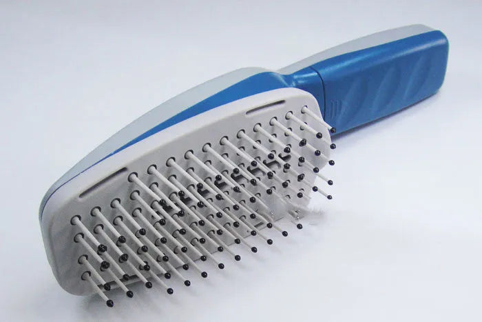 A white pet comb with a removable brush head and a handle housing negative ion and active oxygen technology.