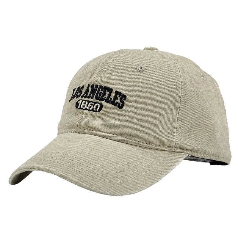 Retro-style adjustable acrylic peaked cap with embroidered letters, shown in a distressed beige colour.