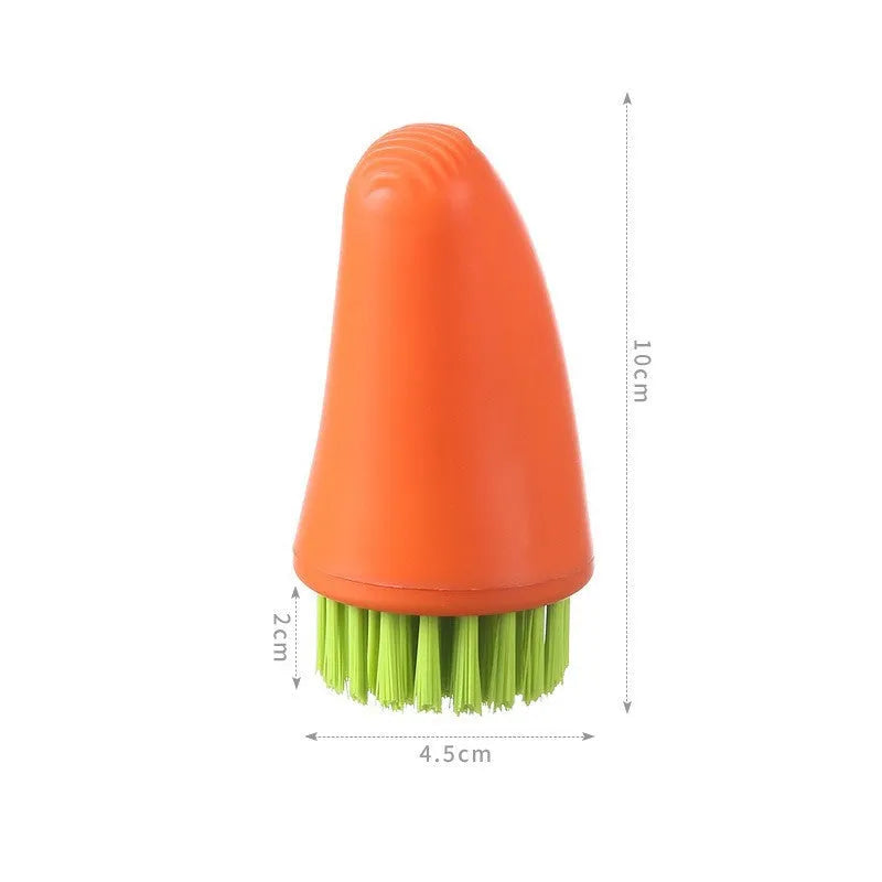 Orange and white carrot-shaped nylon kitchen cleaning brush with radish pattern on a wooden surface.