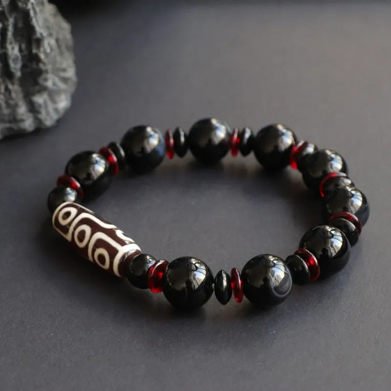 Black agate dzi bead bracelet with hand-woven construction and geometric 11mm beads
