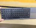 Tri-fold folding Bluetooth keyboard shown both open and closed, with integrated touchpad