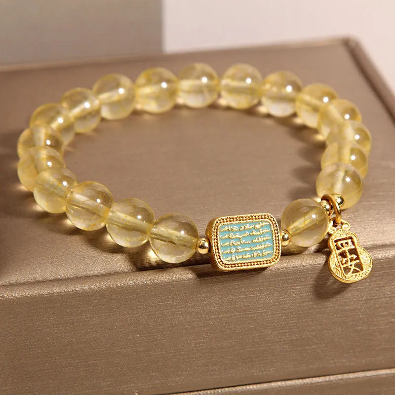 Women's yellow citrine crystal bracelet with sparkling rhinestone details on wrist.